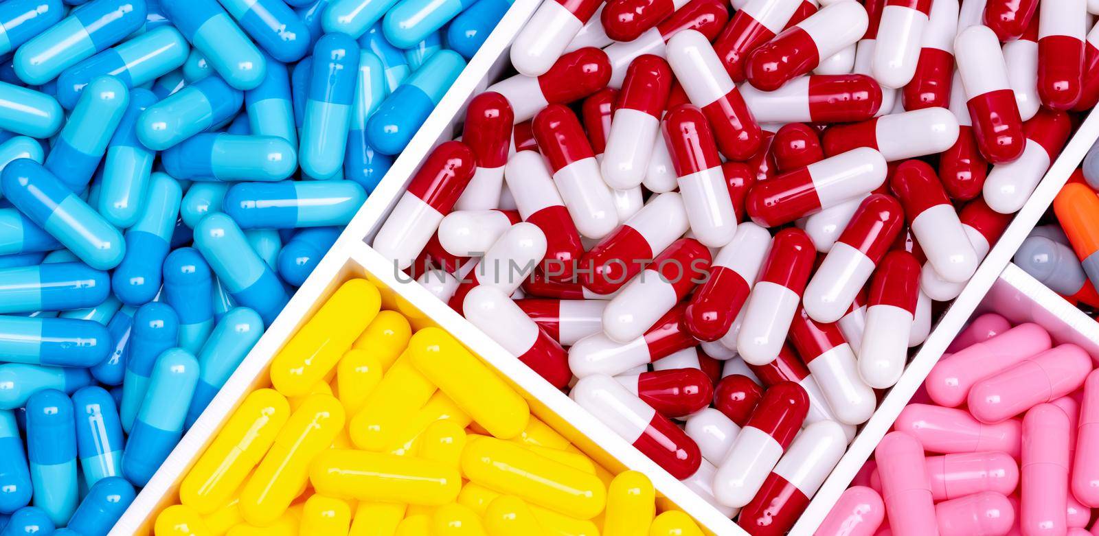 Antibiotic drugs. Top view of painkiller capsule pills and supplements capsule in plastic tray. Pharmaceutical industry. Pharmacy banner. Prescription drugs. Antibiotic drug selection. Drug of choice. by Fahroni