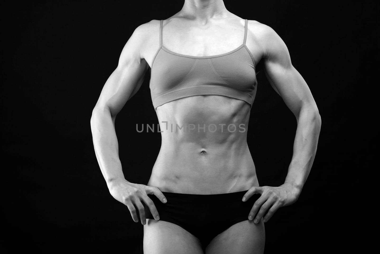 Muscular female torso on black background