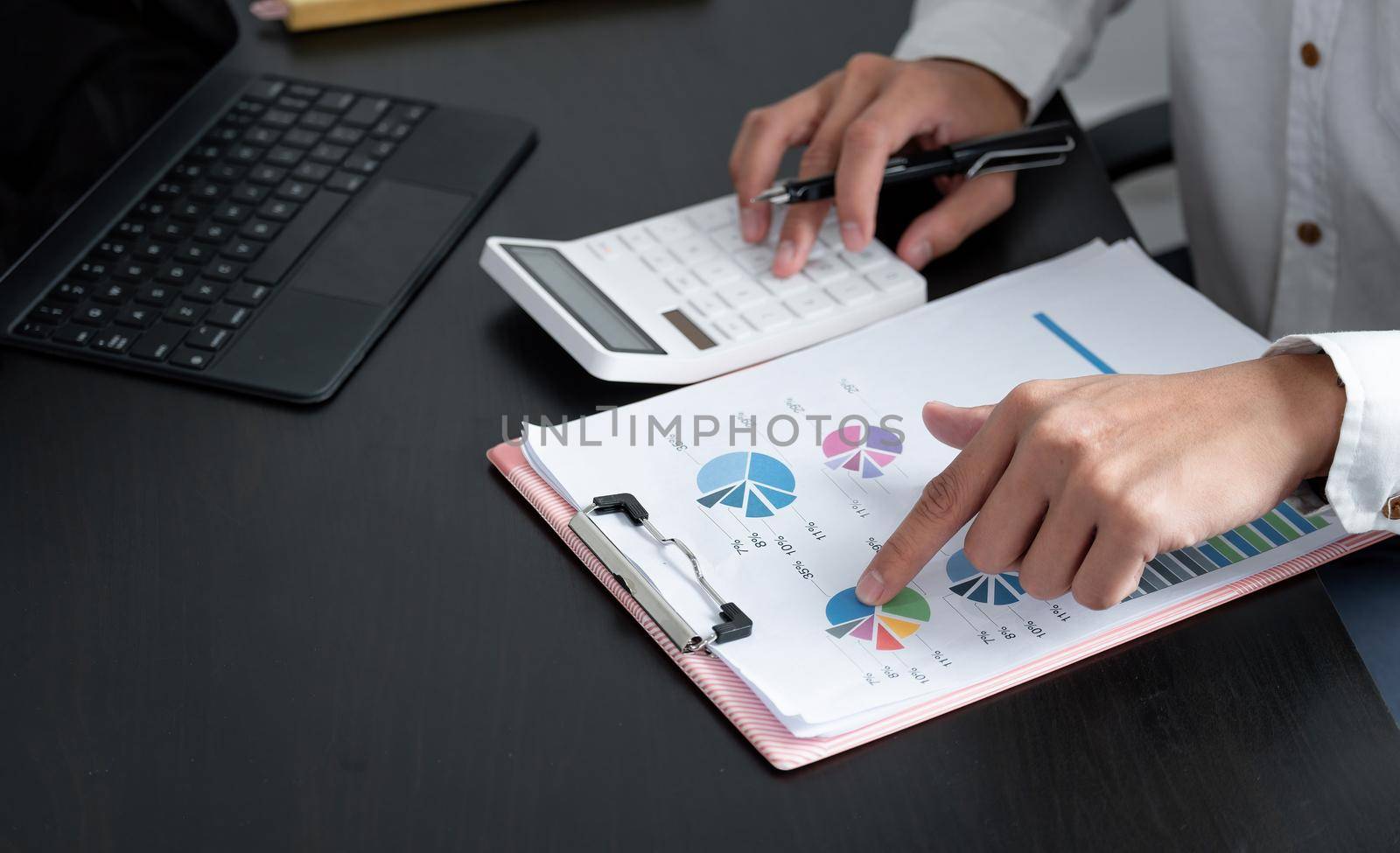 accounting man concept. businessman working using calculator with charts report in office.