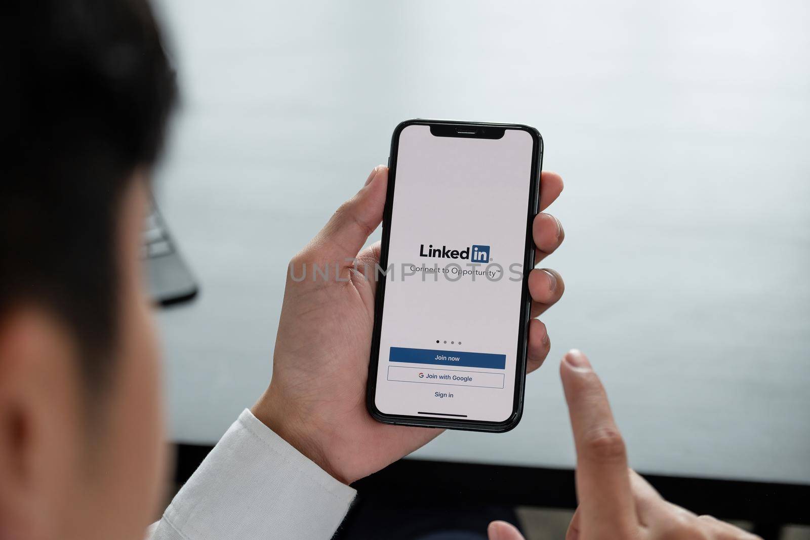 CHIANG MAI, THAILAND, APR 06, 2019 : A man holds Apple iPhone Xs with LinkedIn application on the screen.LinkedIn is a photo-sharing app for smartphones by nateemee