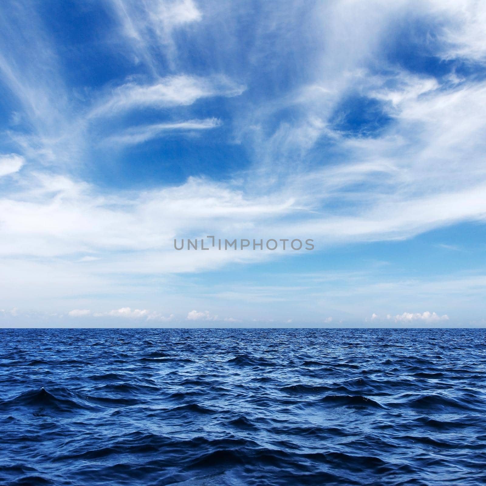 blue sea and cloudy sky over it