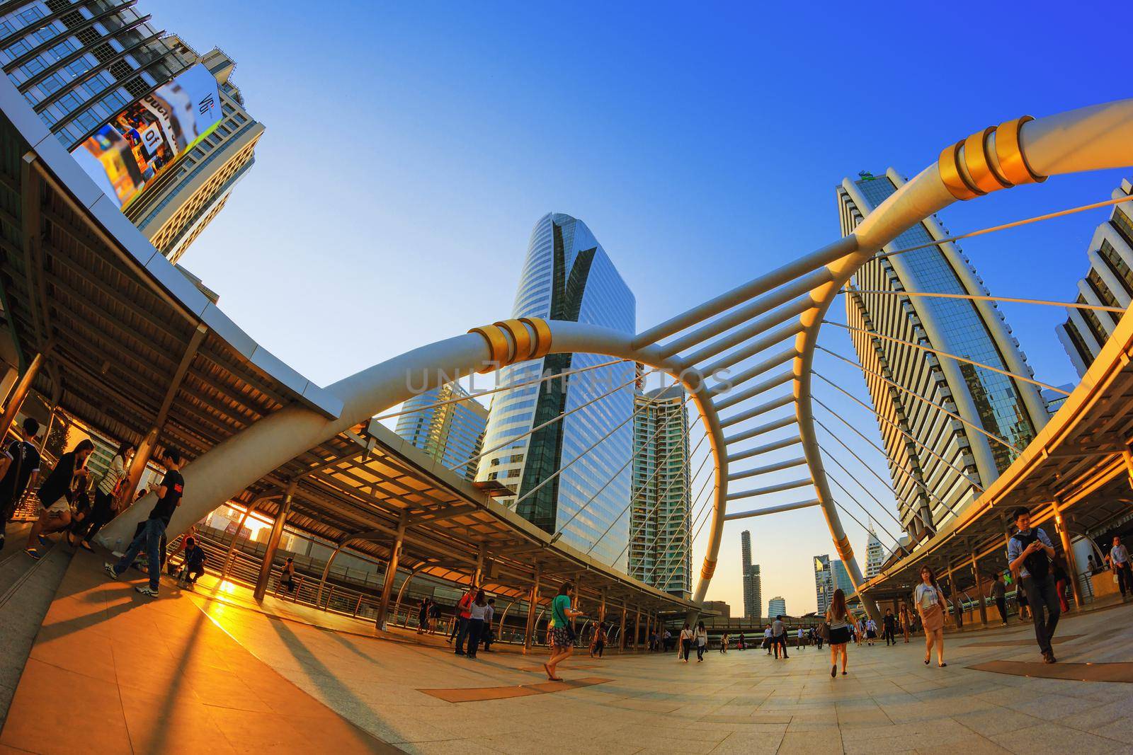 BANGKOK - Apr 21: Unidentified people walk along a skywalk in Sathorn on Apr 21, 2015 in Bangkok, Thailand. Home to international companies, Sathorn is the Thai capital's central business district.