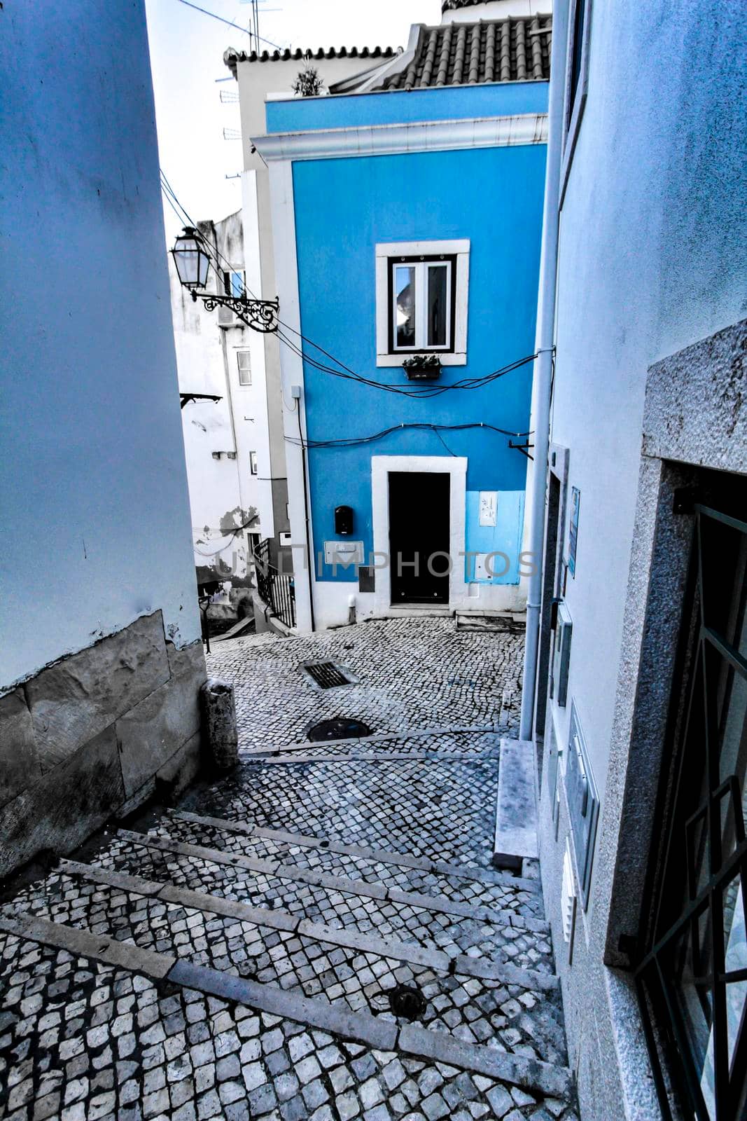 Narrow and colorful streets with majestic facades, windows and balconies of Lisbon city in Portugal in a cloudy day