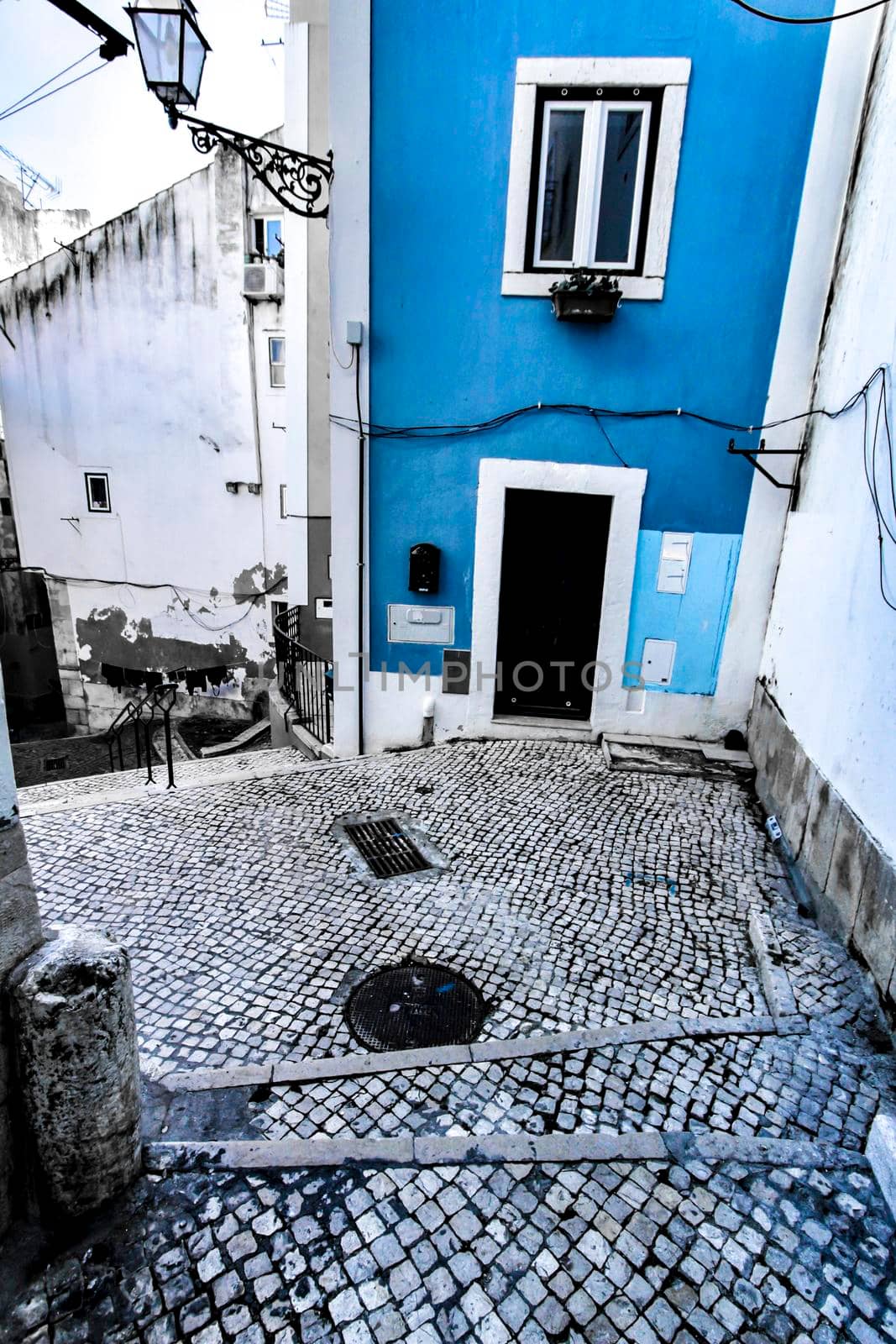 Narrow and colorful streets with majestic facades, windows and balconies of Lisbon city in Portugal in a cloudy day