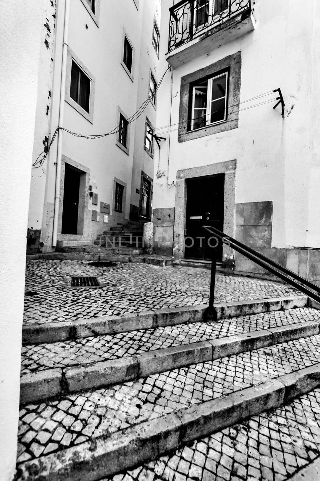 Narrow and colorful streets with majestic facades, windows and balconies of Lisbon city in Portugal in a cloudy day