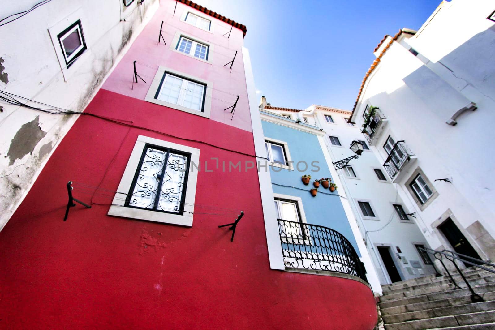 Narrow and colorful streets with majestic facades, windows and balconies of Lisbon city in Portugal in a cloudy day