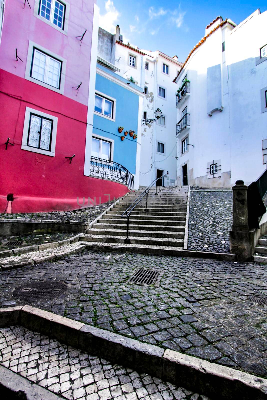 Narrow and colorful streets with majestic facades, windows and balconies of Lisbon city in Portugal in a cloudy day