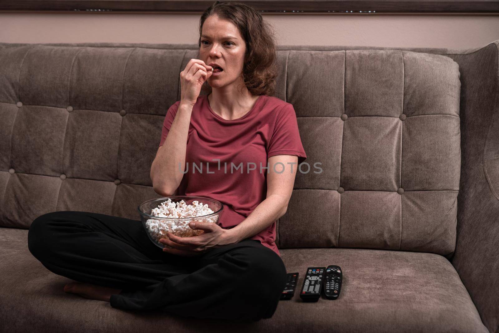 emotions when watching TV at home with popcorn. by Edophoto