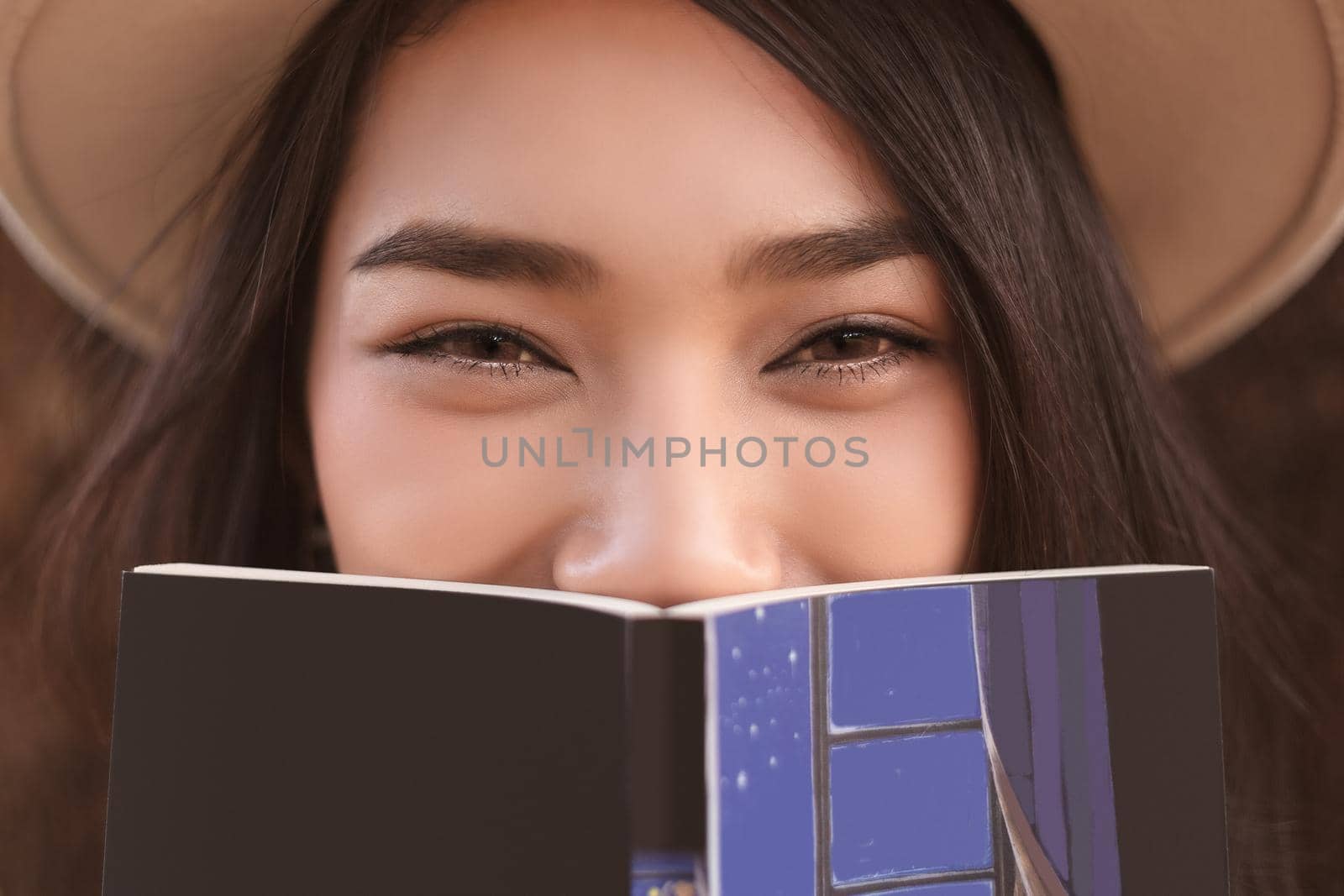 serious young, beautiful girl holding an open book