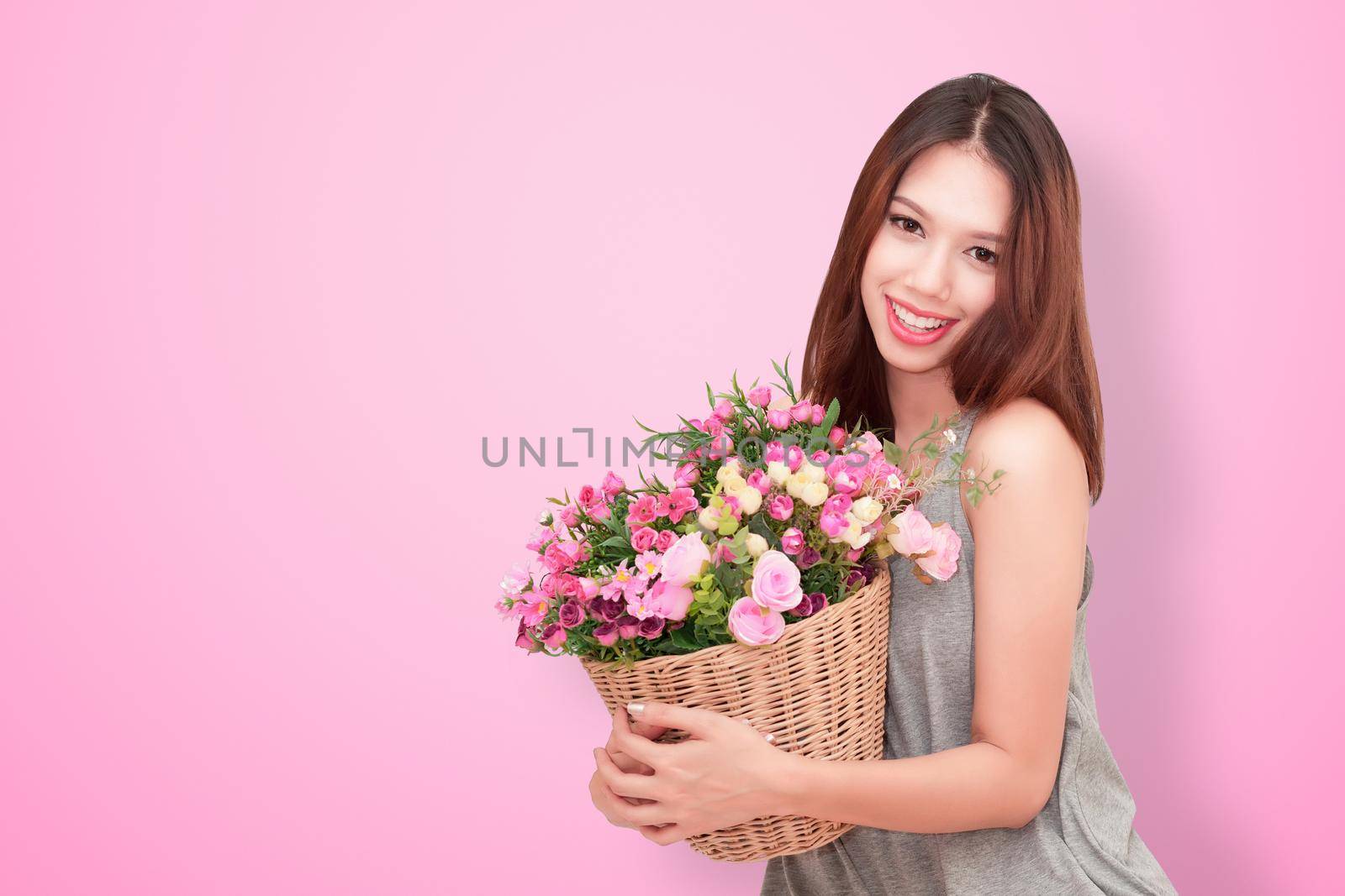 Girl holding a basket of flowers.  Isolated on white.