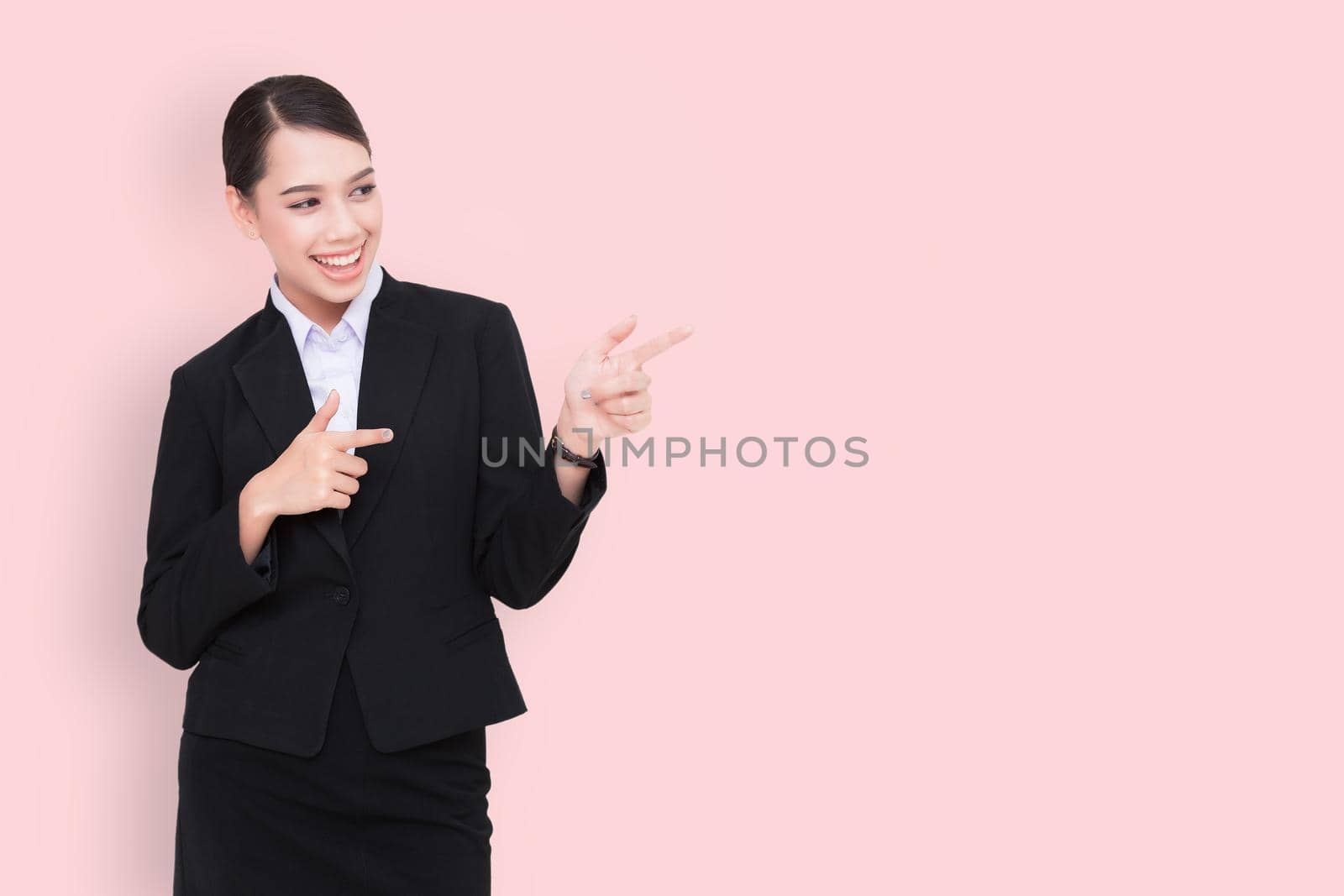 Business woman smiling and pointing her finger to the  blank space .