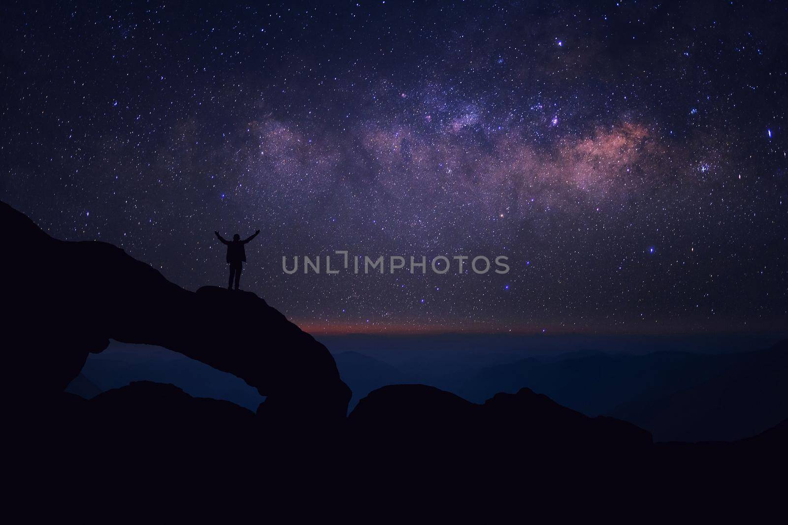 Man who feels on top of the world looking at the milky way