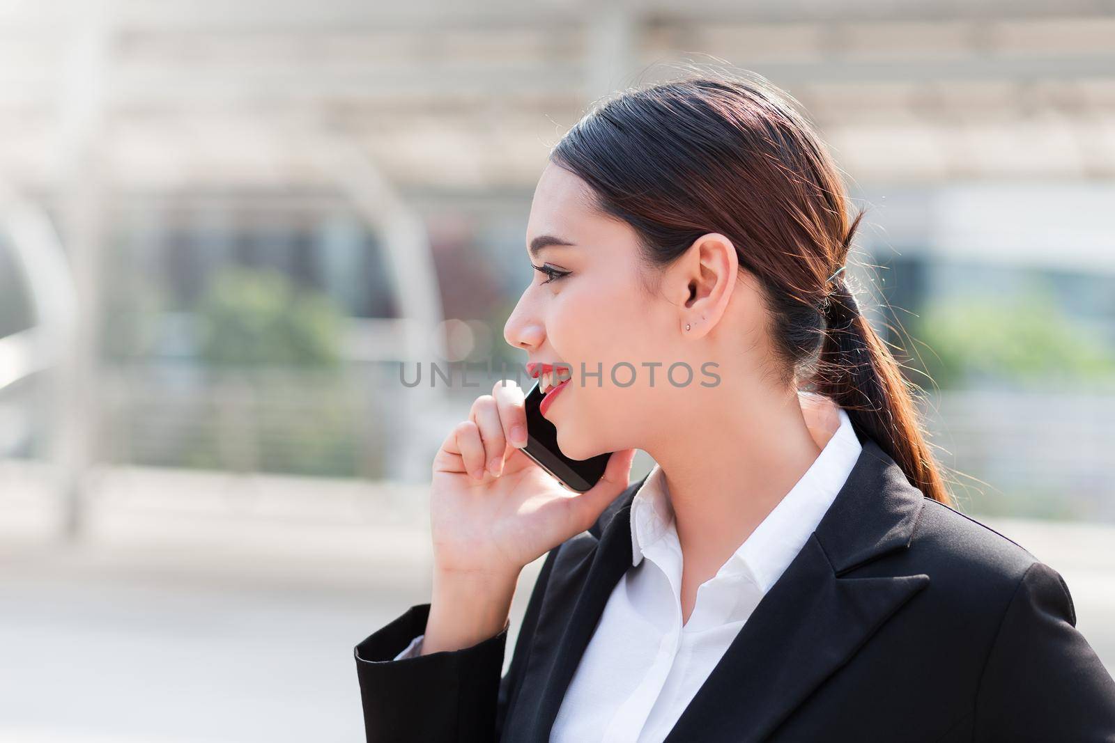 Attractive businesswoman talking on mobile phone with client.