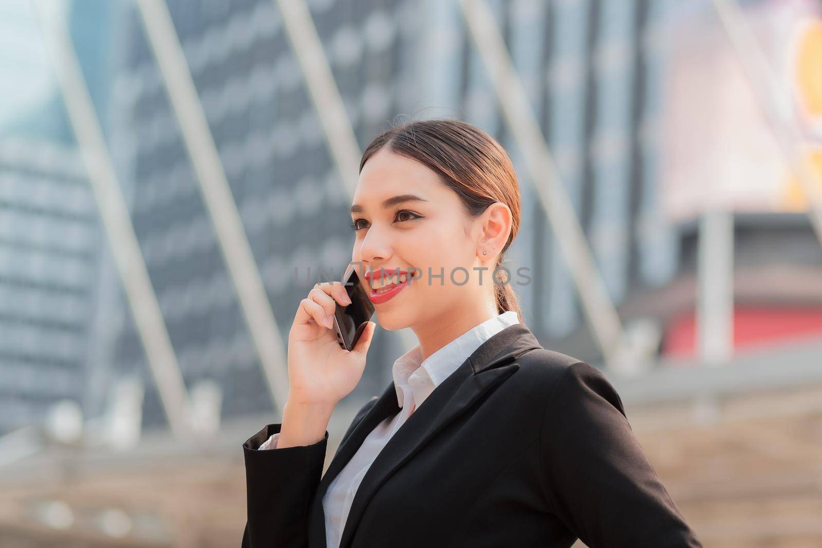 Attractive businesswoman talking on mobile phone with client.