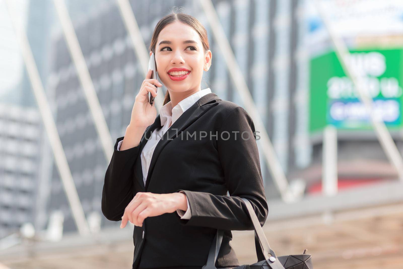 Attractive businesswoman talking on mobile phone with client.