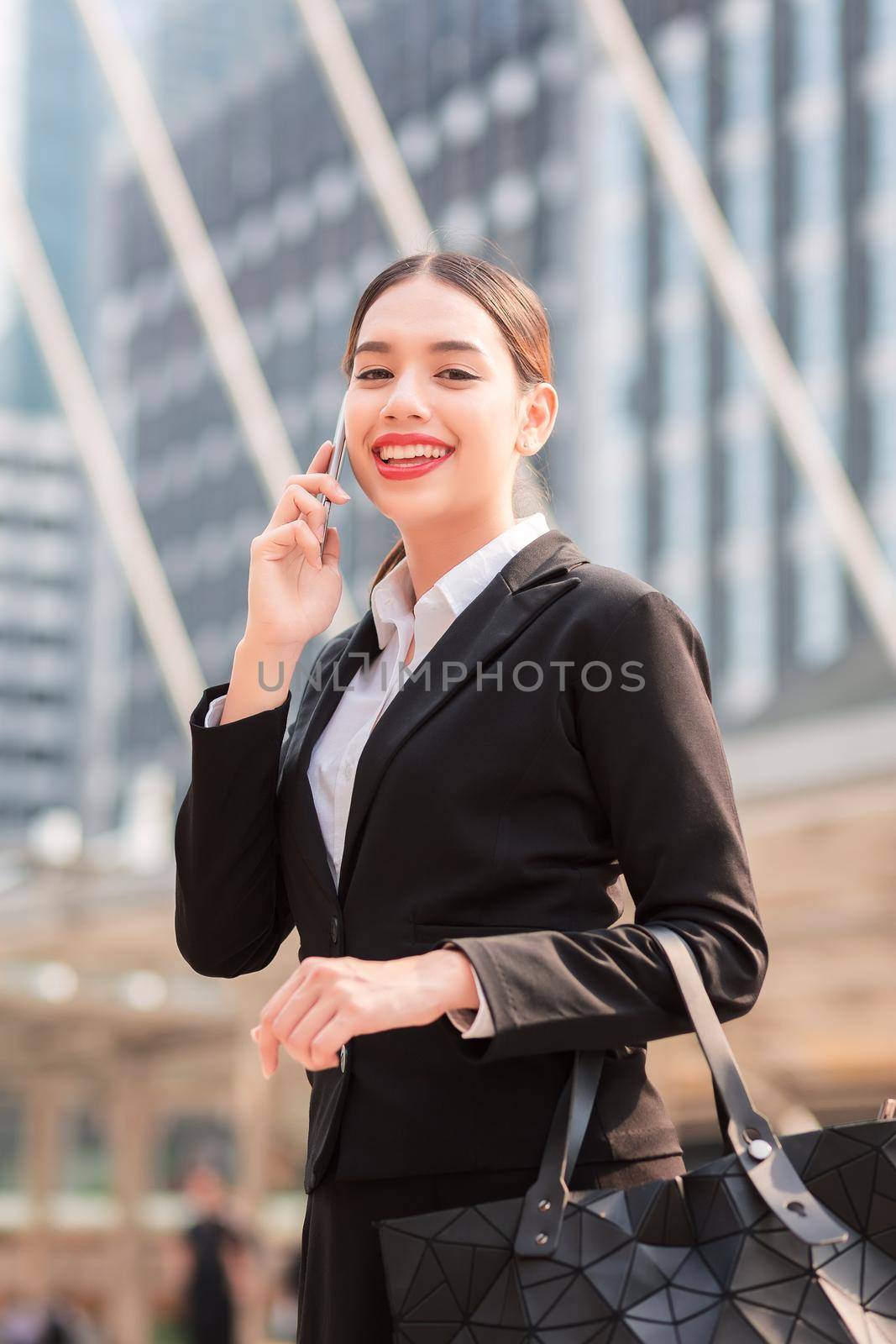 Attractive businesswoman talking on mobile phone with client.