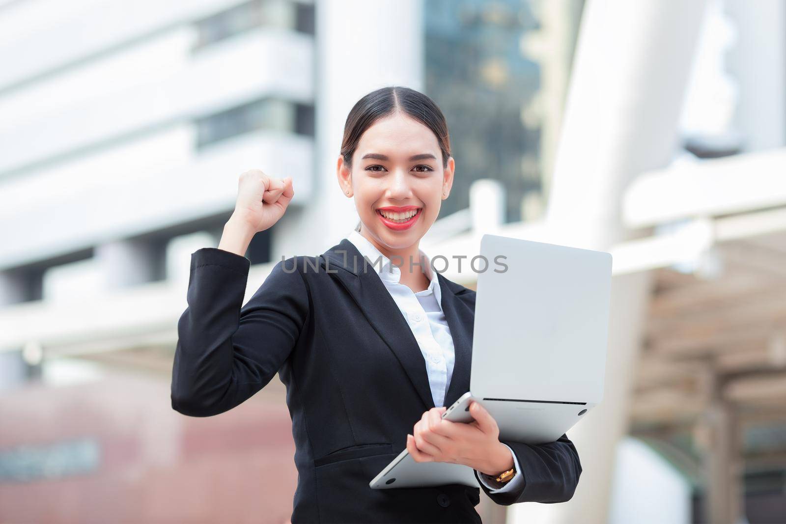 Business success - Celebrating businesswoman overlooking the city center