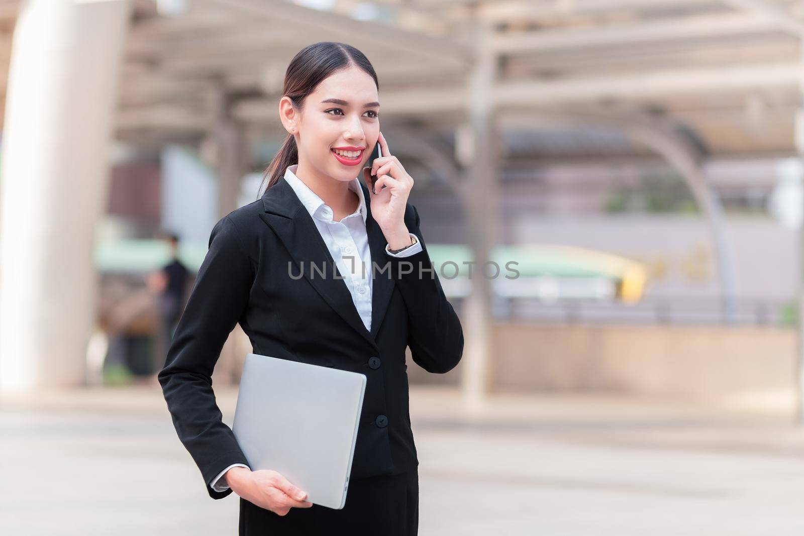 Attractive businesswoman talking on mobile phone with client.