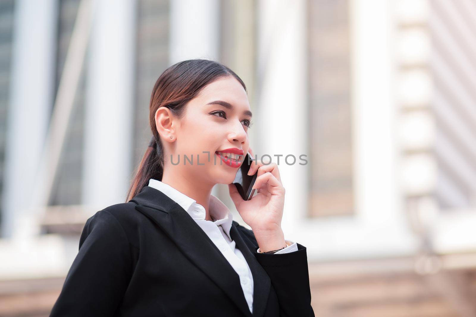Attractive businesswoman talking on mobile phone with client.