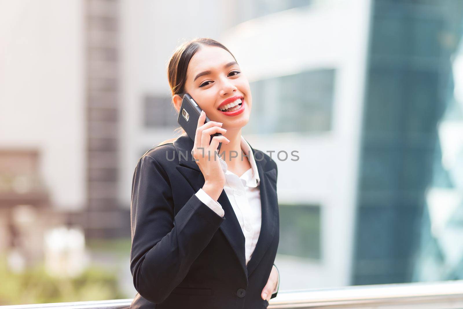 Attractive businesswoman talking on mobile phone with client.