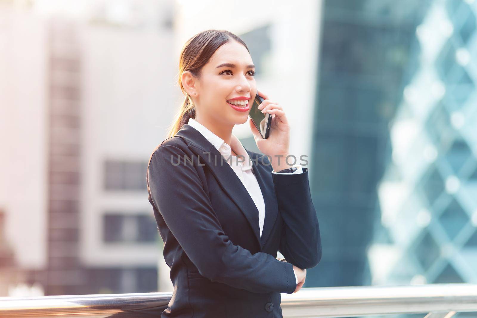 Attractive businesswoman talking on mobile phone with client.