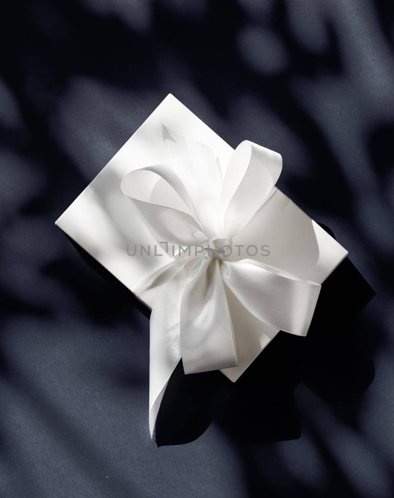 Anniversary celebration, shop sale promotion and luxe surprise concept - Luxury holiday white gift box with silk ribbon and bow on black background, luxe wedding or birthday present