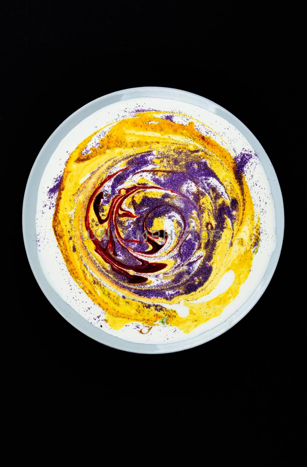 A plate with yellow paint and circular stains on a dark background.Abstract art. Search for material for art work.
