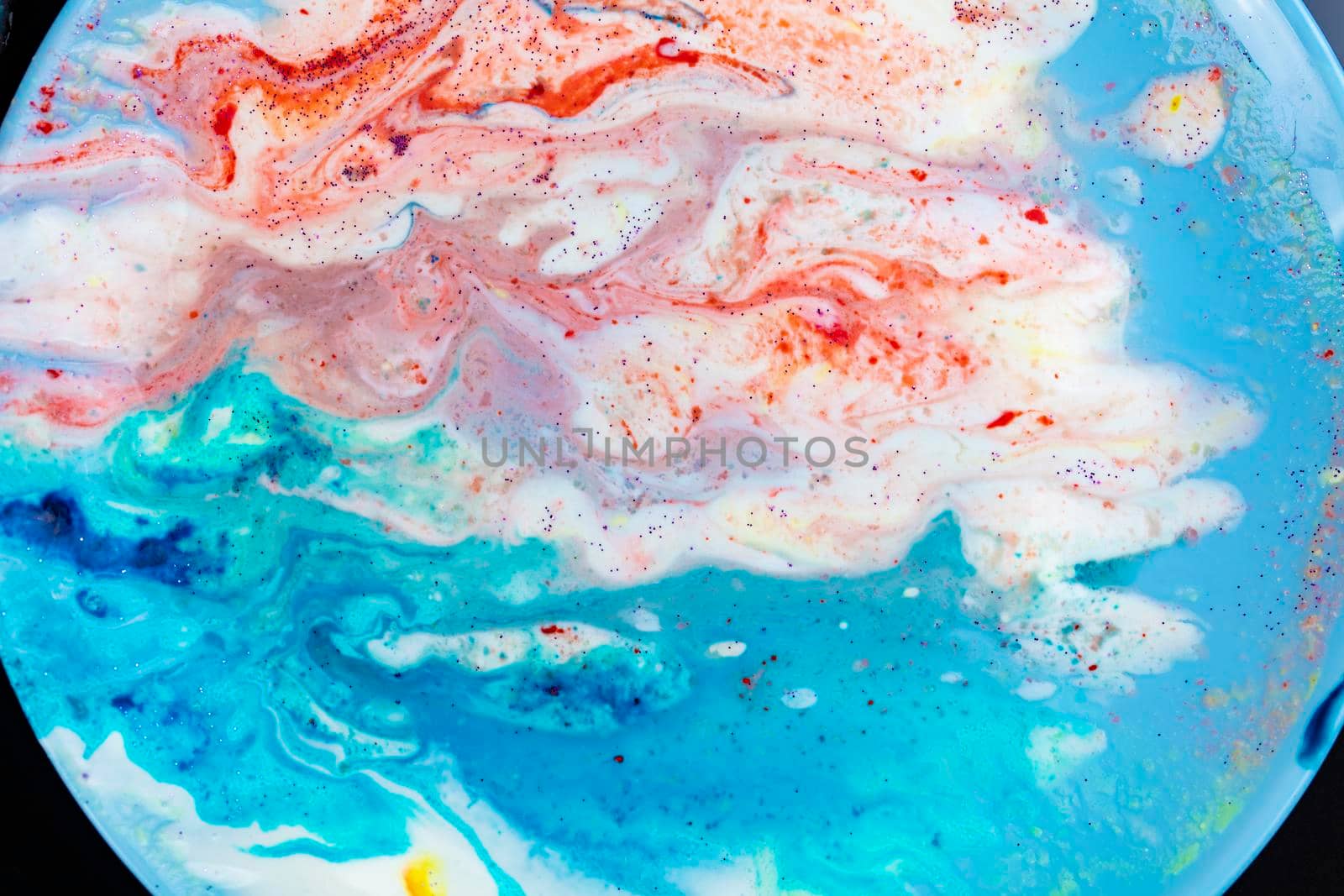 The background is acrylic soft blue with pink and sparkles. Colorful marble texture. Fluid liquid marble. Art picture. Avant-garde creativity.