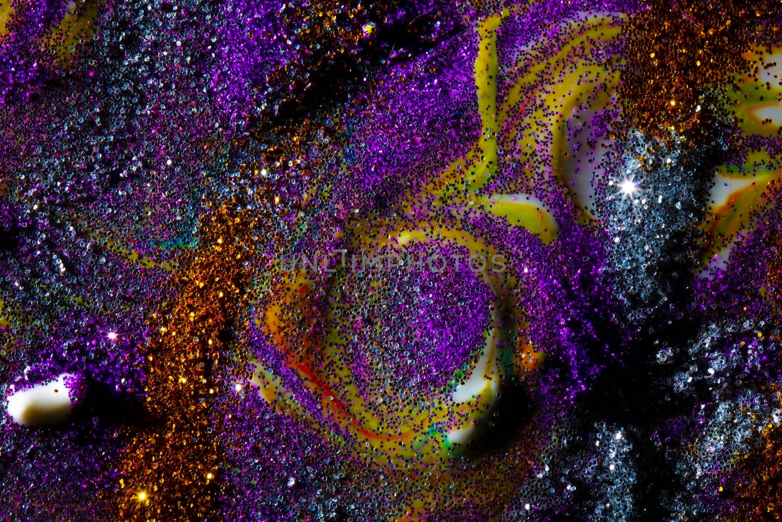Multi-colored dark background sprinkled with purple and gold sparkles with streaks and waves. Contemporary creativity. A colorful avant-garde painting with rich texture. A background made up of many shapes and materials.