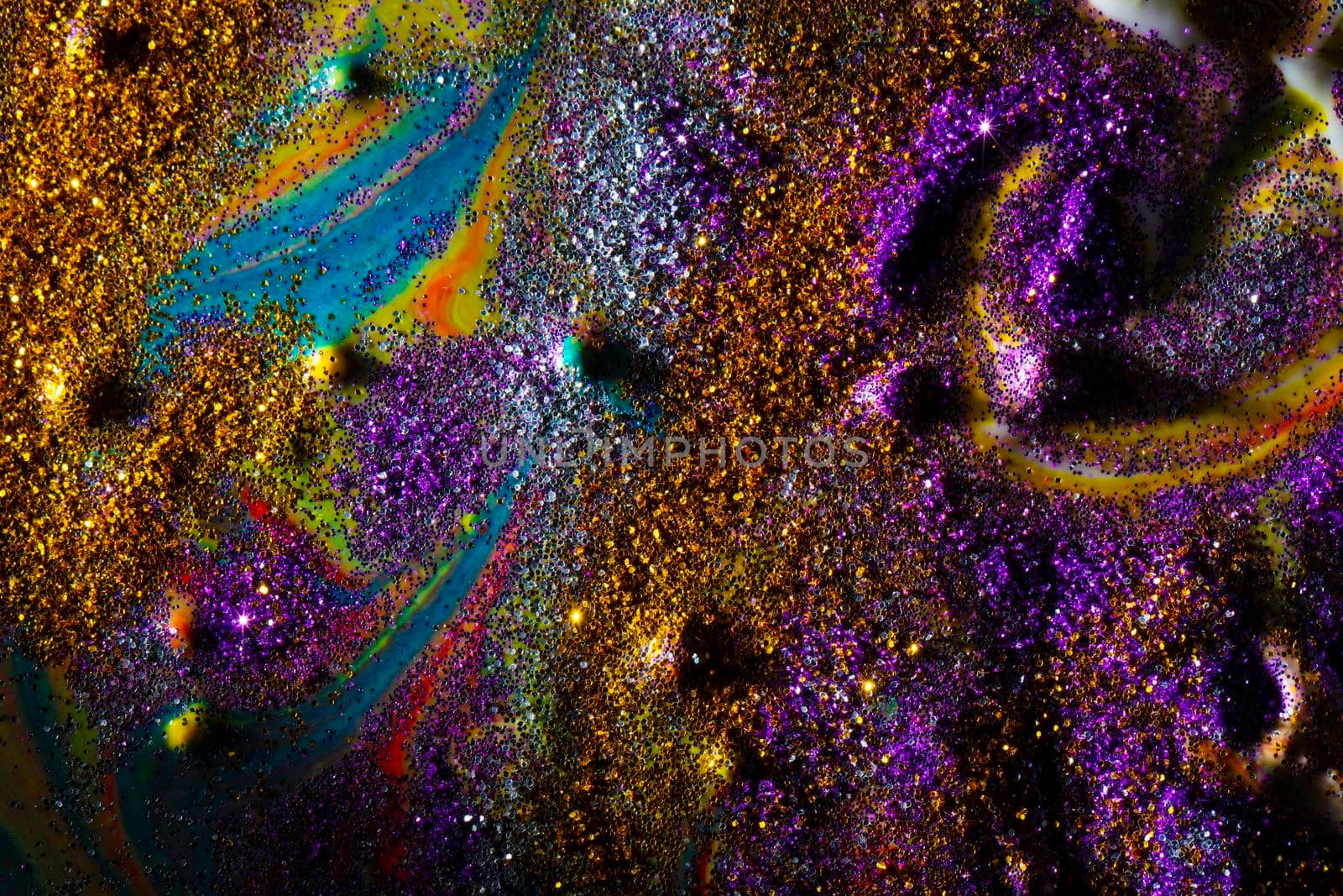 Multi-colored dark background sprinkled with purple and gold sparkles with streaks and waves. Contemporary creativity. A colorful avant-garde painting with rich texture. A background made up of many shapes and materials.