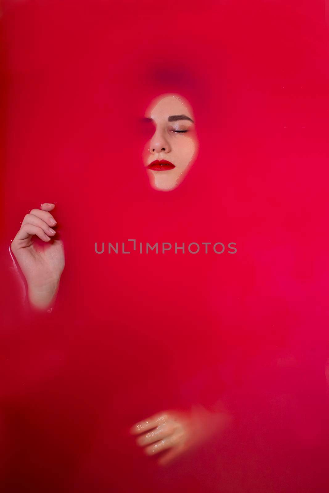 portrait of a beautiful brunette in red water. horror films. Photoshoot in the bathroom. copy space by oliavesna