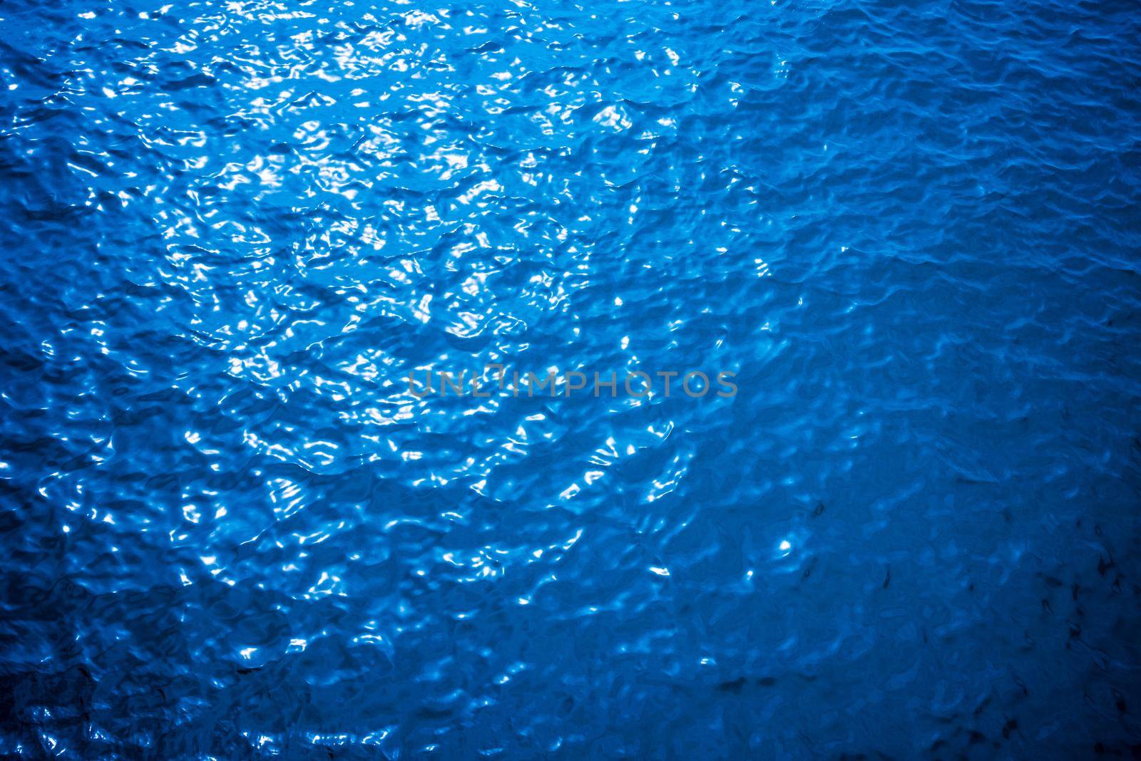 Blue turquoise water surface texture of the sea has small ripple pattern reflecting the shining evening sunlight at sunset, Beautiful nature of the ocean from the top aerial view for summer background