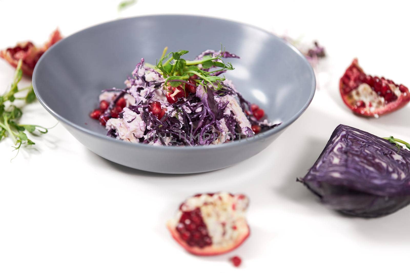 Bowl with appetizing purple cabbage salad with grenade.  by SerhiiBobyk