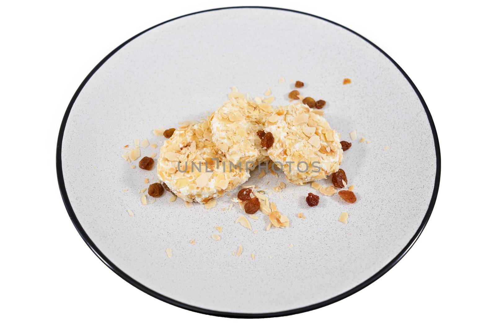 Top view close up of delicious three dietary sweet cheesecakes sprinkled with raisins and nuts on white background. Concept of dessert with a good composition without sugar.