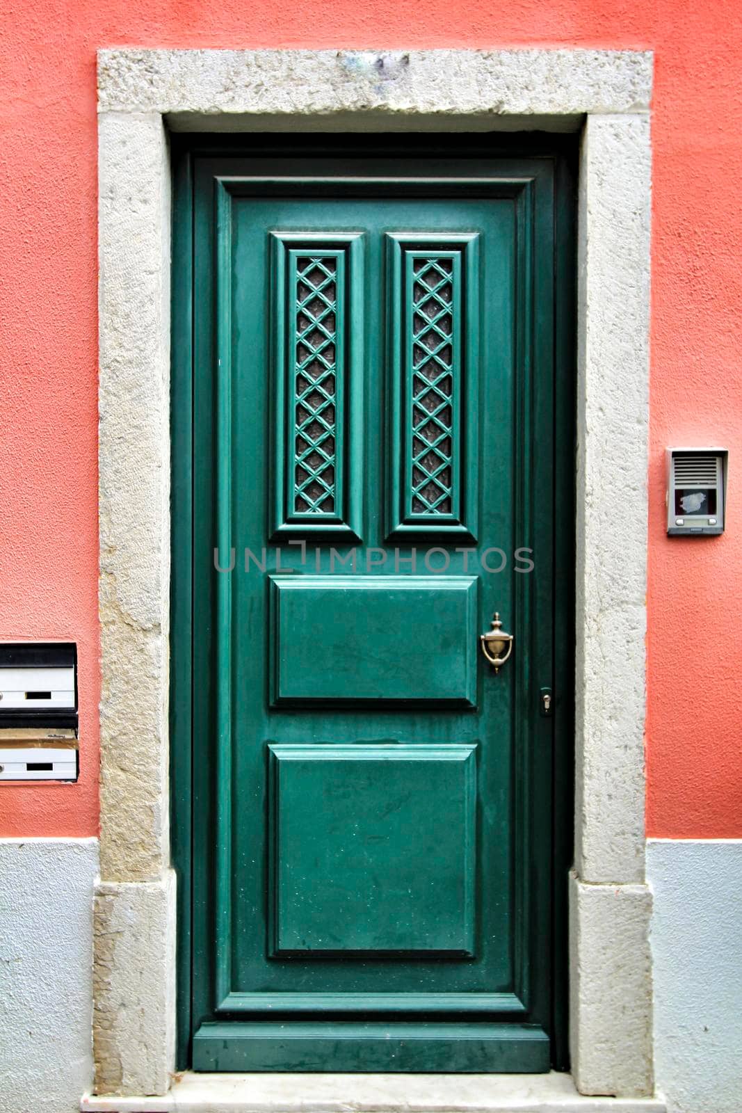 Old and colorful green wooden door with iron details in Lisbon, Portugal