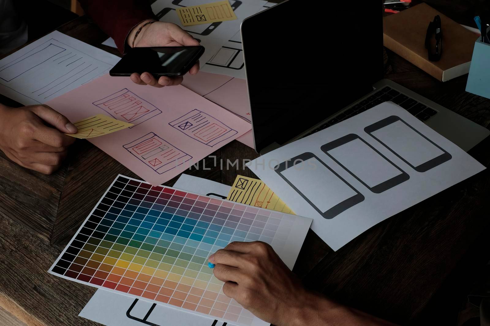 Until creating a mobile application, a developer compares color and interface wireframes.