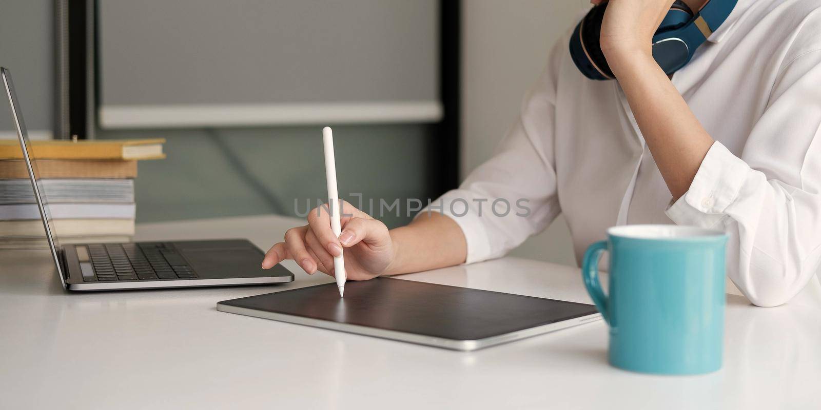 Close up of woman student busy studying using laptop make notes in notebook while write watching webinar or online training course on computer by wichayada