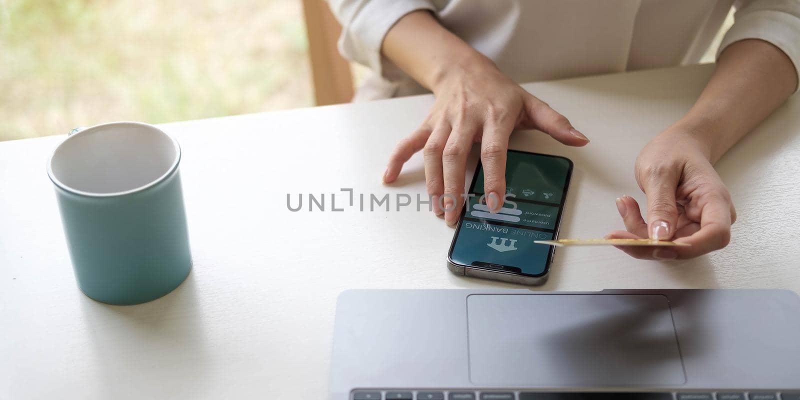 businesswoman hand using smart phone, tablet payments and holding credit card online shopping, omni channel, digital tablet docking keyboard computer at office in sun light.