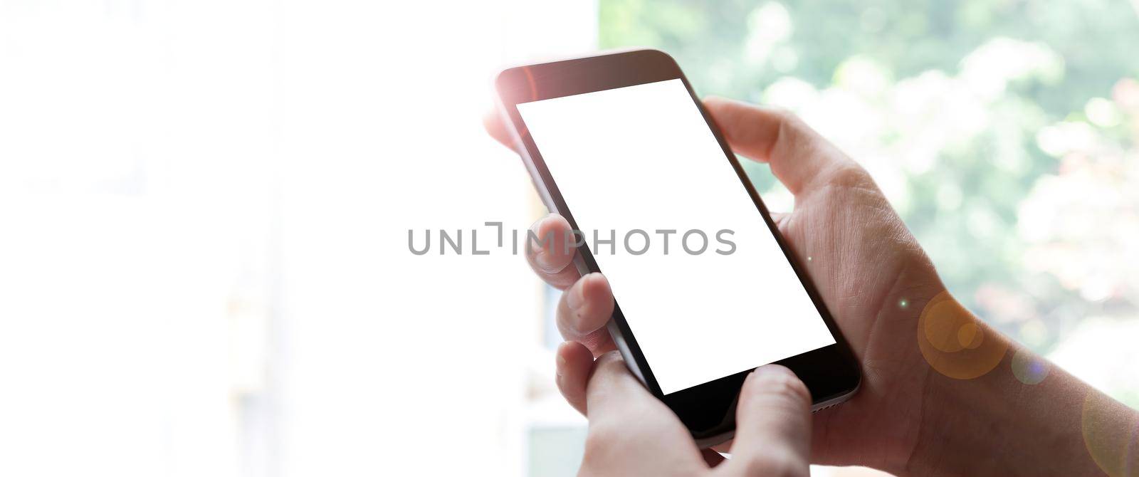 Woman hand holding smartphone with blur bokeh. Blank screen mobile phone for graphic display montage by nateemee