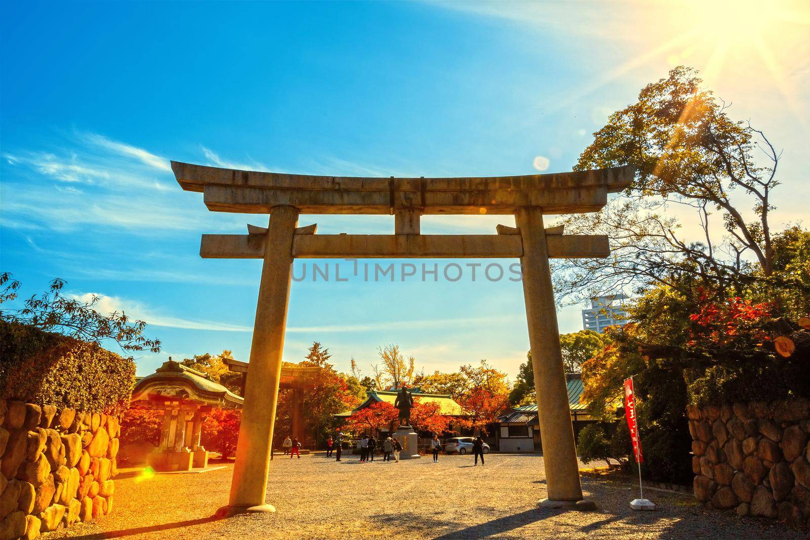 Osaka, Japan - 21 Nov 2018 -Old stone gate of shrine with sun rays in morning