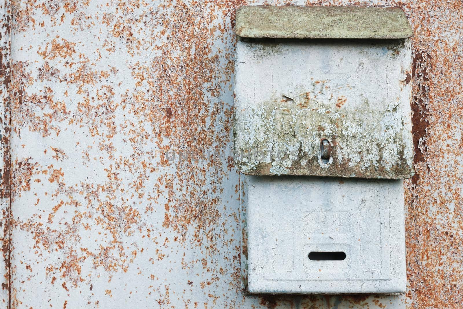 Old mailbox for paper letters. Rusted metal blue wall.