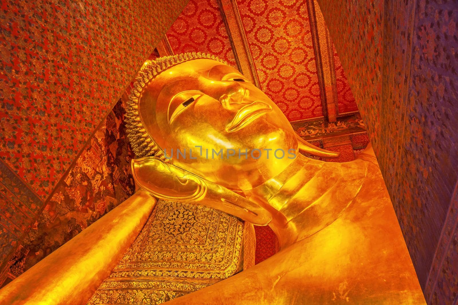 Beautiful face of Reclining Buddha,and thai art architecture in Wat Phra Chetupon Vimolmangklararm (Wat Pho) temple in Thailand.