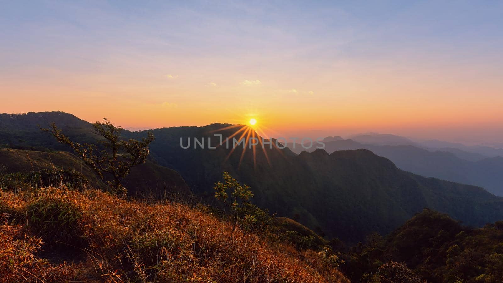 Colorful sunset in the mountains landscape. Dramatic overcast sky.
