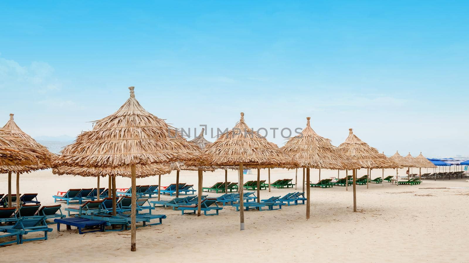 White sand beach with relaxing chairs by samarttiw