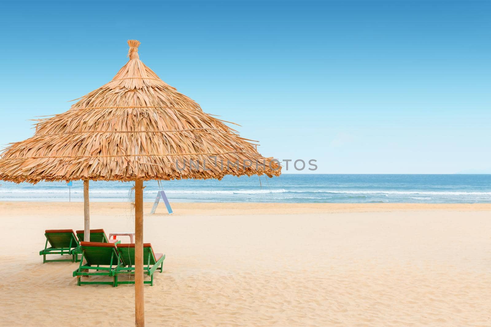 White sand beach with relaxing chairs at sunny day in Vietnam