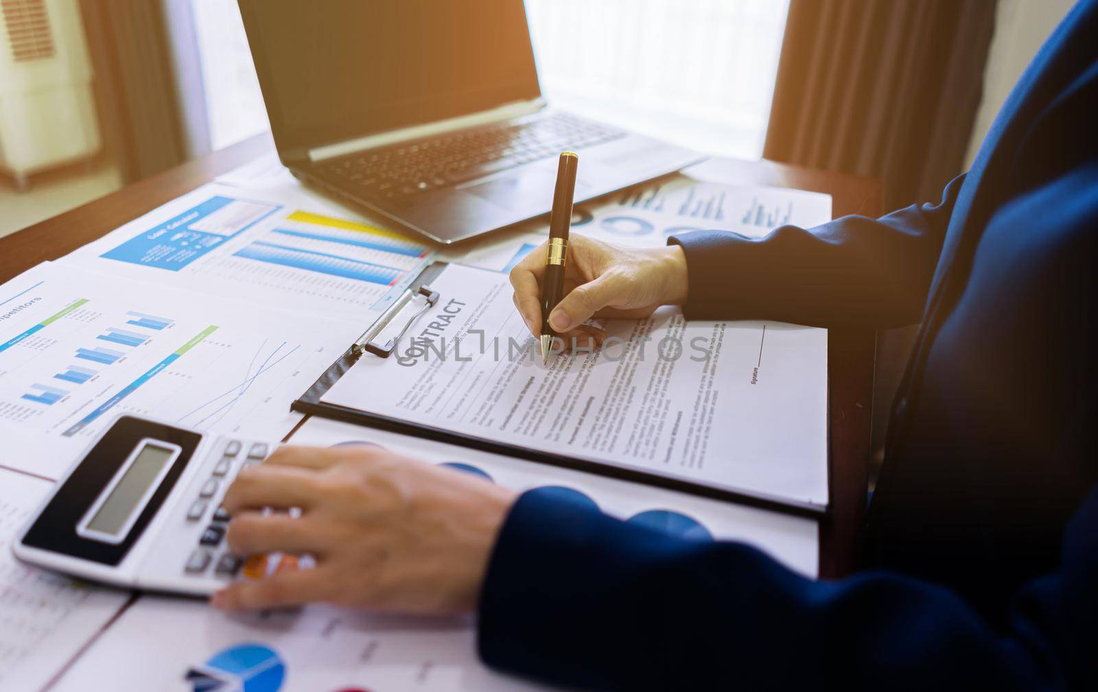 Accountant women calculate and writing contract documents on the table with statistic paper, laptop, graph analysis.