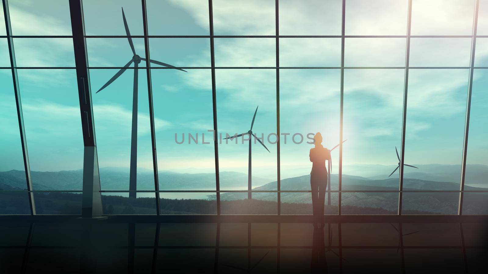 A silhouette of a business woman is standing against an office window overlooking the wind farms.