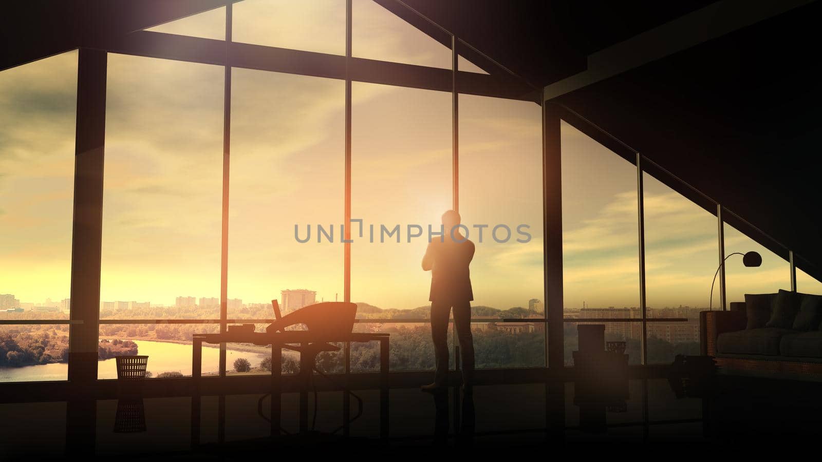 A silhouette of a man in a suit stands in front of a panoramic window and looks at the dawn cityscape.