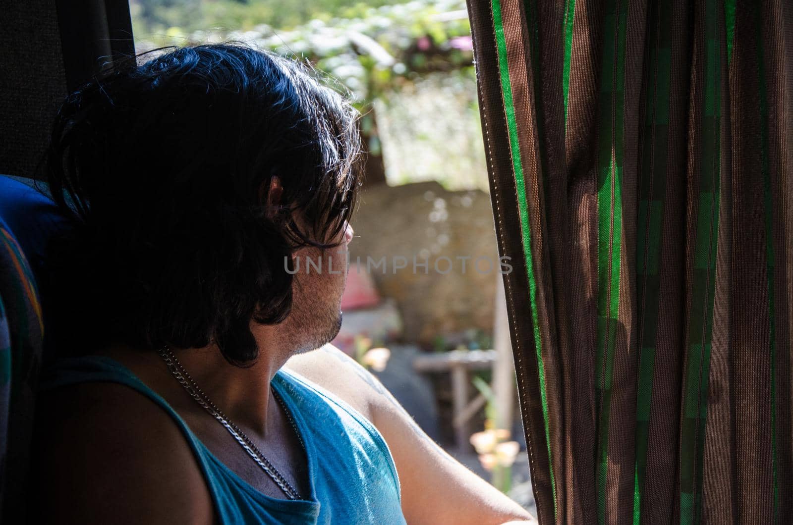 Man sitting on the bus looking through the window at the landscape