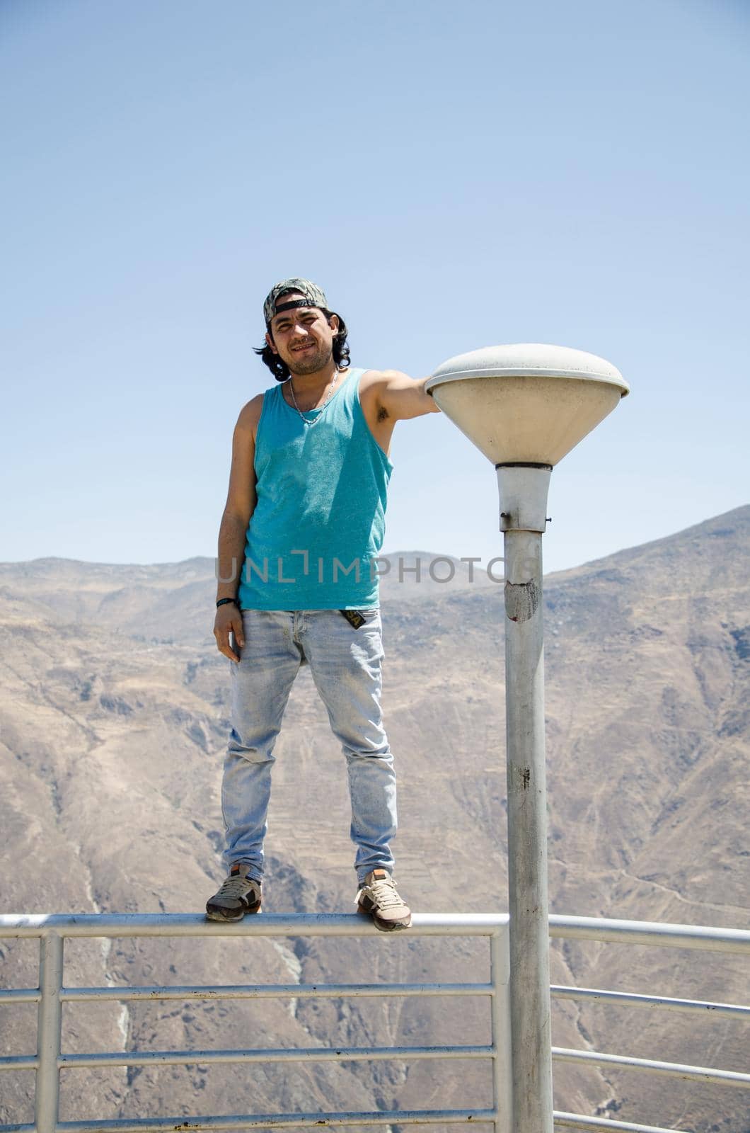 Attractive happy young tourist with cap with mountains background in Marcahuasi